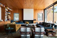 a living room filled with furniture and wooden walls