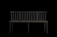 a black wooden bench sitting in the dark