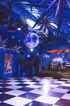 a disco ball is hanging from the ceiling in a room with black and white checkered flooring