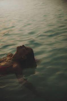 a woman floating on top of a body of water