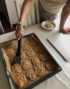 a person cutting cookies on top of a pan with a knife and fork in it