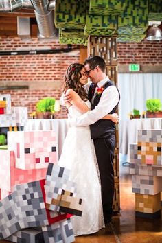 a bride and groom are hugging in front of some paper cubes on the floor