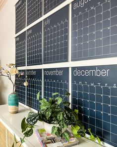 a wall with calendars and plants on it