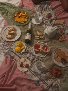 a table topped with lots of food on top of a bed