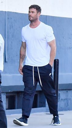 a man in white shirt and black pants walking