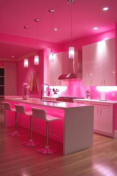 a kitchen with pink lighting and white counter tops in the center, along with bar stools