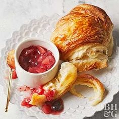 a croissant on a plate with fruit jam