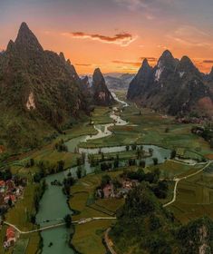 an aerial view of a valley with mountains in the background and water running through it