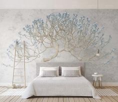 a bedroom with a large tree mural on the wall and bed in front of it