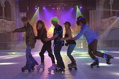 several people on skateboards in front of brightly colored lights