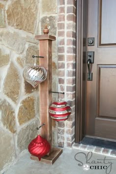 two red vases are hanging on the side of a brick wall next to a door