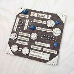 a wooden board with different types of buttons and other items on it, sitting on a white surface