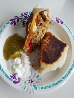 a burrito with salsa and sour cream on a plate