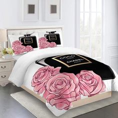 a bed with pink roses on it in a white and black color scheme is shown