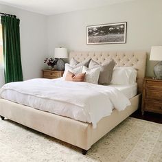 a bedroom with a large bed and green curtains