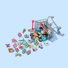 a shopping cart filled with lots of stickers and magnets on a blue background