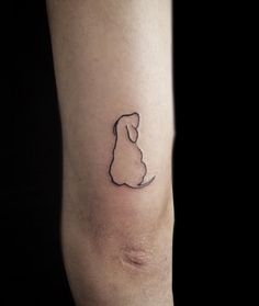 a small dog tattoo on the right arm and leg, with a black outline behind it