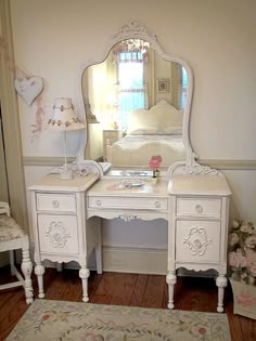 a white desk with a mirror and chair