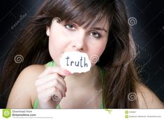 a young woman holding a piece of paper with the word truth written on it in front of her mouth