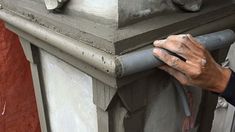 a man is working on the side of a building with cement and concrete mortars