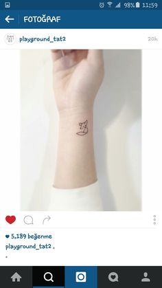 a small wrist tattoo with a cat on the left hand and a heart in the middle