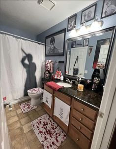 the shadow of a man is cast on the bathroom wall above the toilet and sink