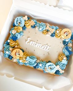 there is a cake in the box that says emmet on it and has blue frosting