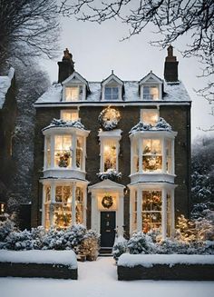 a large house covered in snow with lots of windows and wreaths on the front