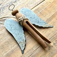 an angel ornament hanging on a wood floor with twine and string attached to it