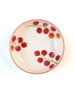 a white plate with red flowers and green stems on the rim, against a white background