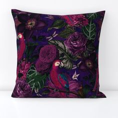 a decorative pillow with purple flowers and birds on the front, along with green leaves