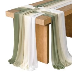 a wooden bench with white and green scarves on it