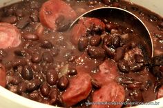 beans and sausage are being cooked in a pot