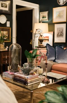 a living room filled with lots of furniture and pictures on the wall above it's coffee table