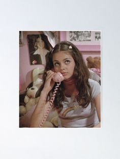 a woman talking on the phone while holding her hand up to her ear poster print