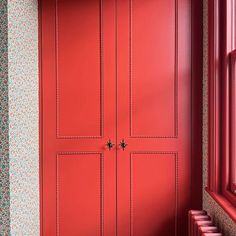 a red door in the corner of a room