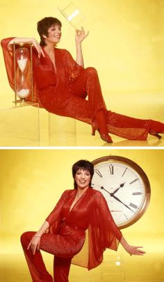 a woman in red is sitting on a chair next to a clock and posing for the camera