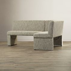 a gray couch sitting on top of a hard wood floor next to a white wall