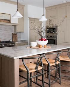 a kitchen island with stools next to it and an oven in the back ground