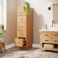 a bathroom with a sink, mirror and wooden cabinet in it's corner next to a potted plant