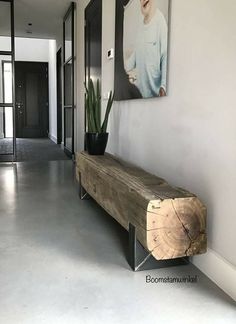 a wooden bench sitting in the middle of a hallway next to a painting on the wall