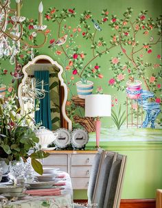 a dining room with green walls and floral wallpaper