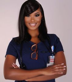 a woman with glasses and a stethoscope is posing for a photo in front of a white wall