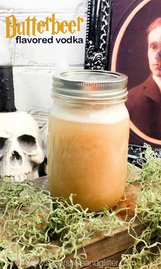 a glass jar filled with liquid next to a skull