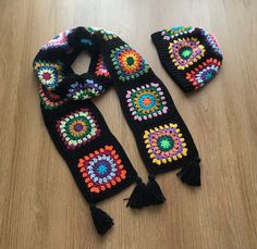 two black crocheted scarfs with multicolored beads and tassels