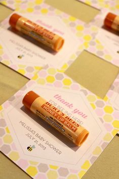 four lip bales sitting on top of a yellow and white tablecloth covered table