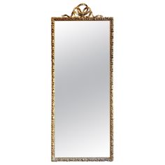 an ornate gold framed mirror with a bow on the front and bottom edge, against a white background