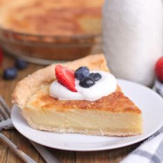 a piece of pie with whipped cream and berries on top is sitting on a plate