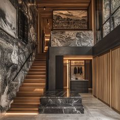 the stairs lead up to the second floor in this modern home with marble and wood accents