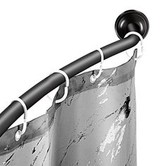 a black and white photo of a curtain with rings on the top, hanging from a metal rod